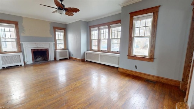 unfurnished living room featuring radiator heating unit and plenty of natural light