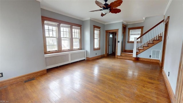 interior space featuring hardwood / wood-style flooring, a wealth of natural light, crown molding, and radiator