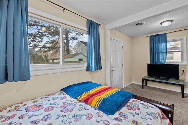 bedroom with carpet floors and a textured ceiling