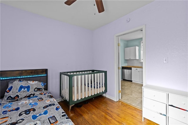 bedroom featuring hardwood / wood-style flooring, ensuite bath, and ceiling fan