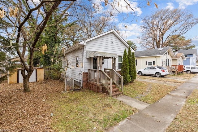 bungalow-style house with a storage unit