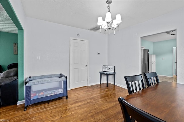 dining area featuring wood-type flooring and a chandelier