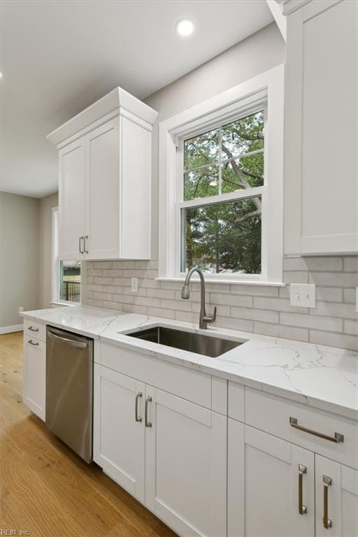 kitchen with dishwasher, white cabinets, sink, decorative backsplash, and light hardwood / wood-style floors