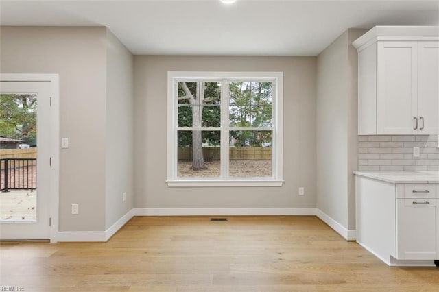 unfurnished dining area featuring light wood-type flooring