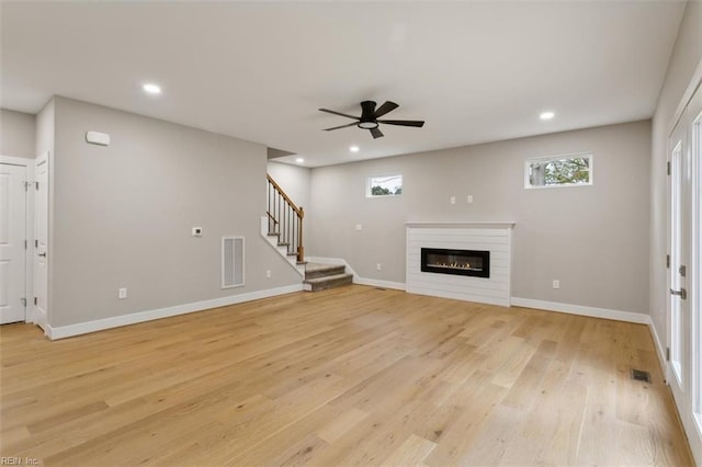 unfurnished living room featuring ceiling fan and light wood-type flooring