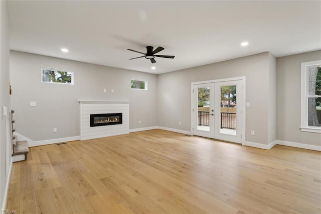 unfurnished living room with ceiling fan, french doors, and light hardwood / wood-style floors