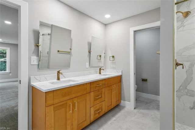 bathroom with toilet, vanity, and tiled shower