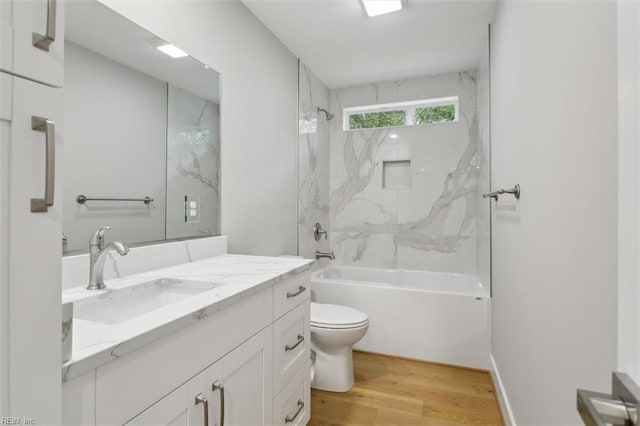 full bathroom with hardwood / wood-style floors, vanity, toilet, and tiled shower / bath combo