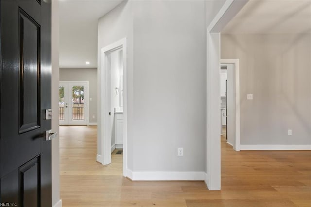 corridor featuring light hardwood / wood-style flooring and french doors