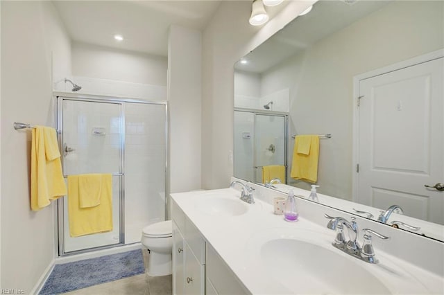 bathroom featuring toilet, vanity, tile patterned floors, and a shower with shower door