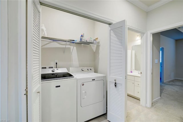 clothes washing area with light colored carpet, independent washer and dryer, and crown molding