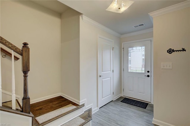 foyer with light hardwood / wood-style flooring and ornamental molding