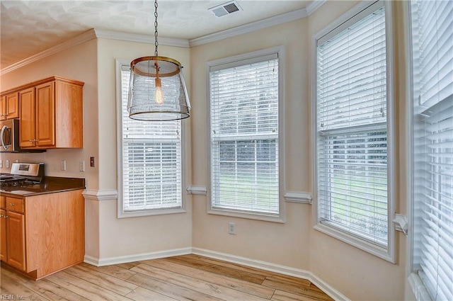 kitchen featuring light hardwood / wood-style floors, ornamental molding, and appliances with stainless steel finishes