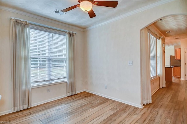 spare room featuring light hardwood / wood-style flooring, ceiling fan, and ornamental molding