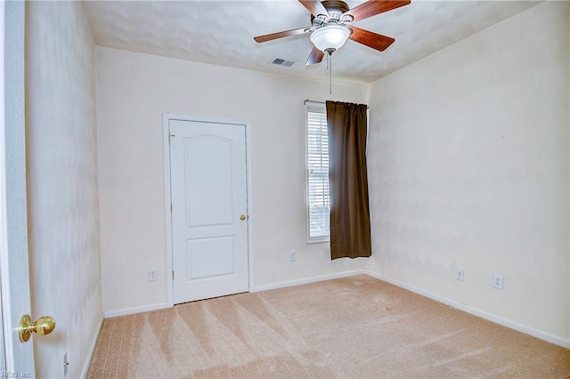 carpeted spare room with ceiling fan