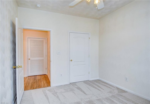 unfurnished bedroom with ceiling fan, a closet, and light carpet