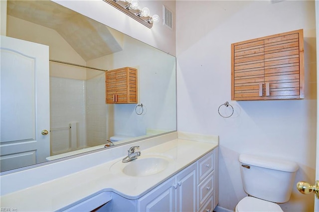 bathroom featuring a shower, vanity, vaulted ceiling, and toilet