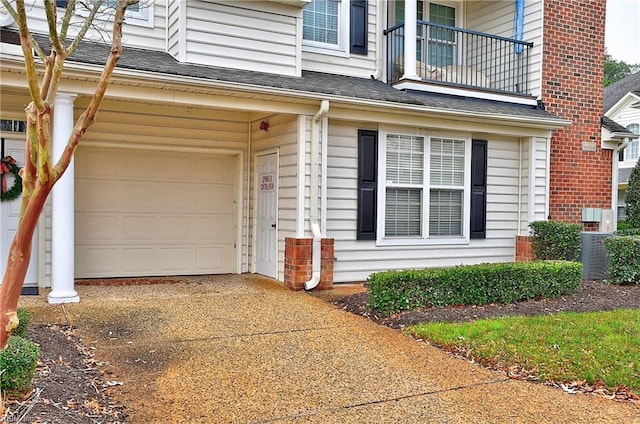 property entrance with central AC, a balcony, and a garage