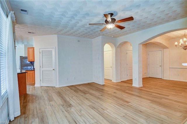 unfurnished living room featuring ceiling fan with notable chandelier, light hardwood / wood-style floors, and ornamental molding