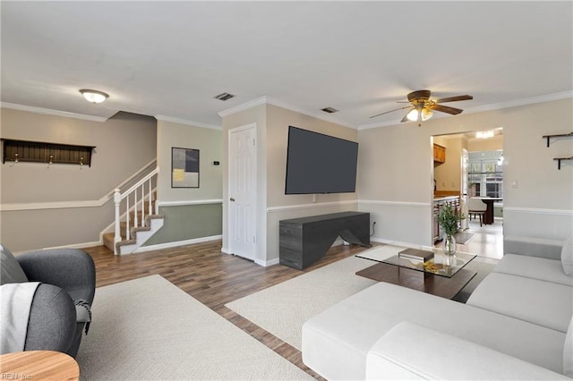 living room with hardwood / wood-style floors, ceiling fan, and crown molding