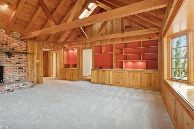 unfurnished living room featuring wooden ceiling, beam ceiling, light colored carpet, and wooden walls