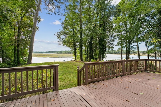 wooden terrace featuring a water view and a yard