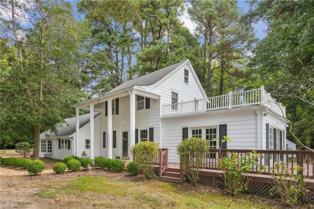 back of property with a balcony and a wooden deck