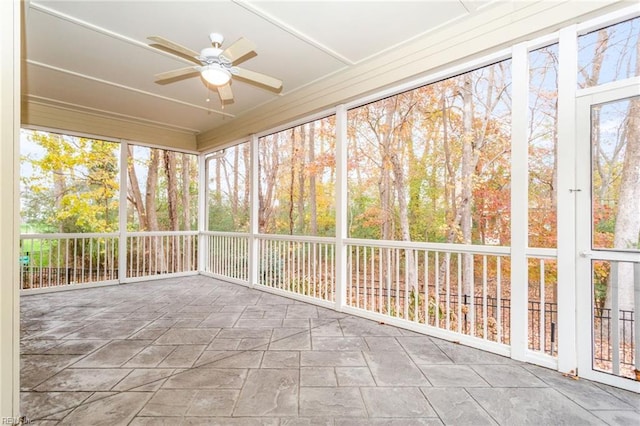 unfurnished sunroom with ceiling fan