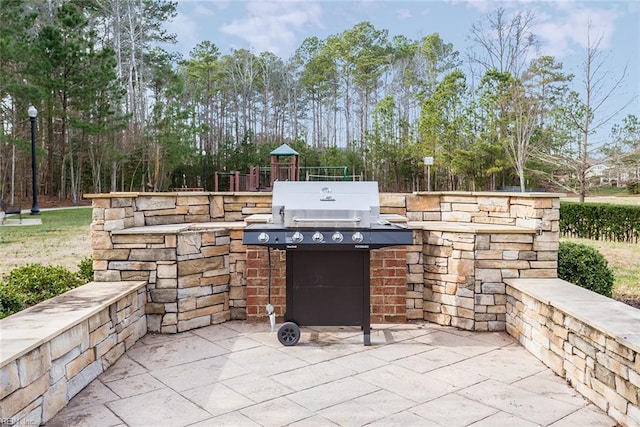 view of patio with a playground and area for grilling