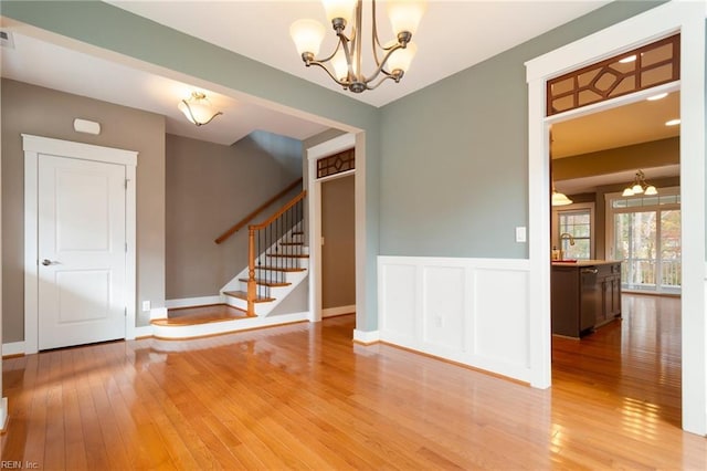 spare room featuring an inviting chandelier and hardwood / wood-style flooring