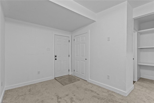 foyer entrance featuring light carpet