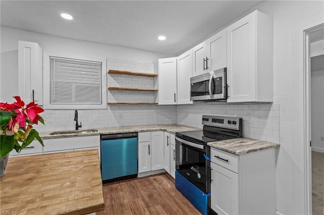 kitchen featuring backsplash, white cabinets, sink, appliances with stainless steel finishes, and dark hardwood / wood-style flooring