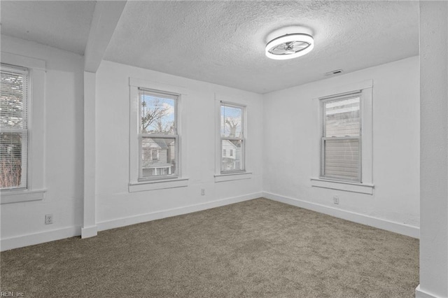 spare room featuring carpet flooring and a textured ceiling