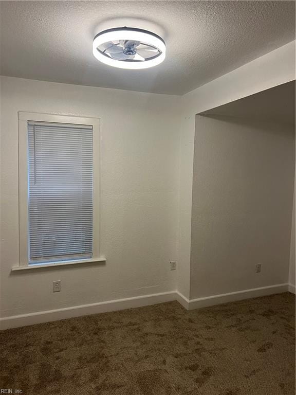 carpeted spare room featuring a textured ceiling