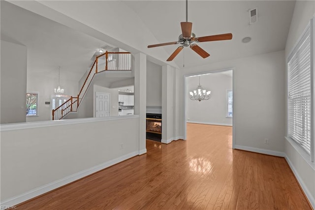 4756 Winterberry Ct, Williamsburg, VA 23188 - empty room with a chandelier, wood finished floors, a ceiling fan, stairs, and high vaulted ceiling