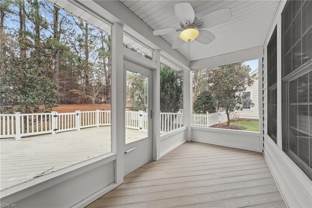 unfurnished sunroom with ceiling fan