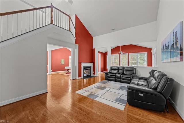 living room with wood-type flooring and high vaulted ceiling