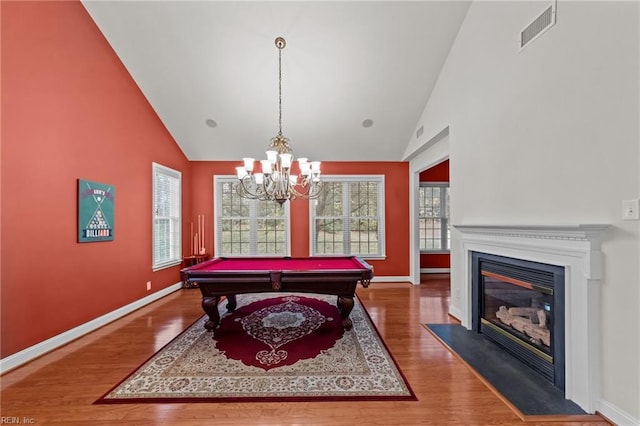 playroom featuring hardwood / wood-style floors, high vaulted ceiling, a notable chandelier, and pool table