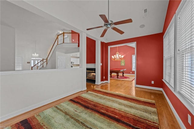 interior space with ceiling fan with notable chandelier, hardwood / wood-style flooring, and pool table