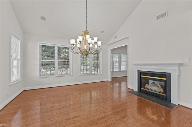 4756 Winterberry Ct, Williamsburg, VA 23188 - unfurnished dining area featuring healthy amount of natural light, a chandelier, wood finished floors, a fireplace with flush hearth, and high vaulted ceiling