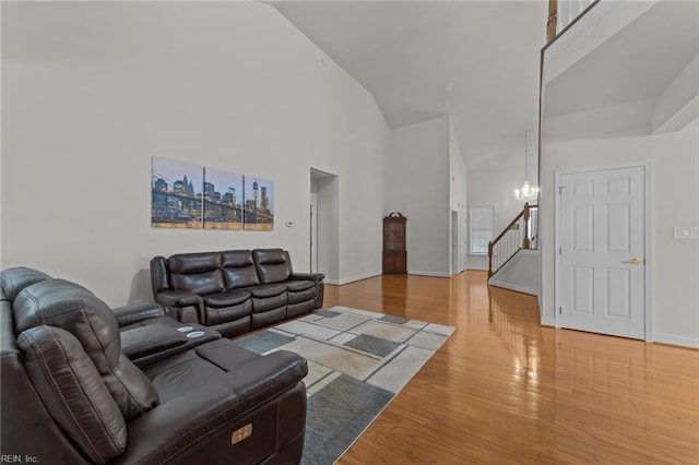 living room with hardwood / wood-style floors, high vaulted ceiling, and an inviting chandelier