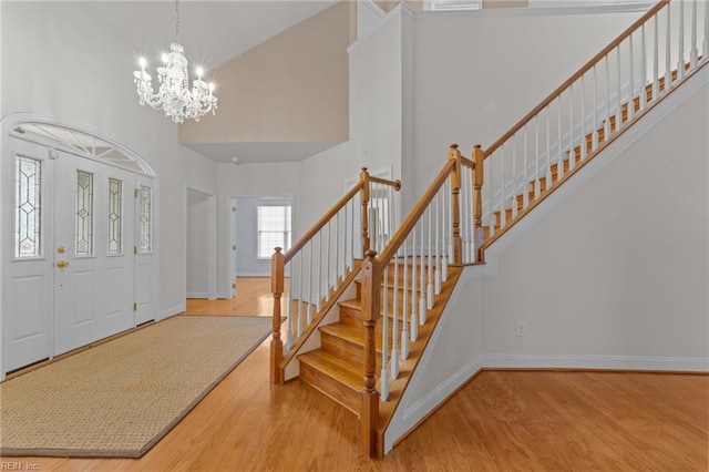 entrance foyer with a high ceiling, hardwood / wood-style flooring, and a notable chandelier