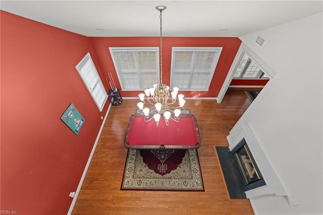 dining room featuring hardwood / wood-style floors, vaulted ceiling, and a notable chandelier