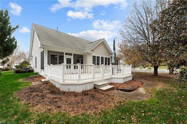 back of property with a yard and a wooden deck