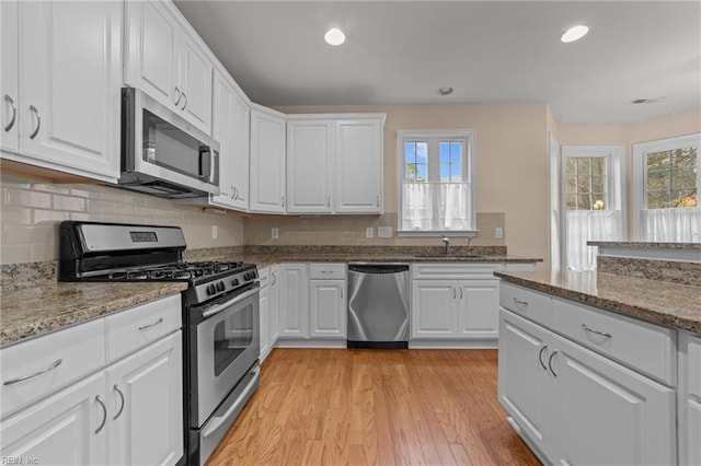 4756 Winterberry Ct, Williamsburg, VA 23188 - kitchen with appliances with stainless steel finishes, plenty of natural light, light wood-style floors, white cabinetry, and recessed lighting