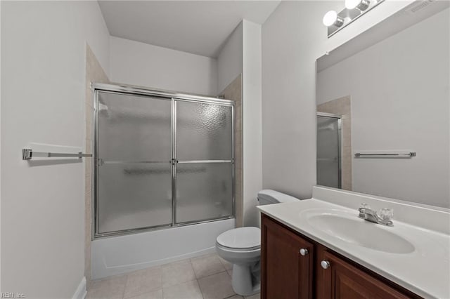 full bathroom featuring tile patterned floors, vanity, toilet, and shower / bath combination with glass door