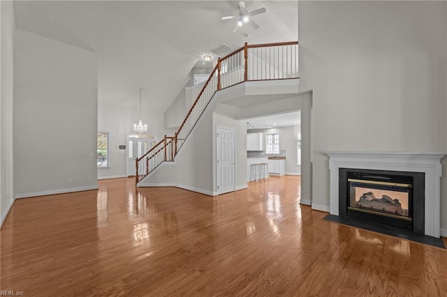 4756 Winterberry Ct, Williamsburg, VA 23188 - unfurnished living room featuring stairway, high vaulted ceiling, ceiling fan, wood finished floors, and a fireplace with flush hearth