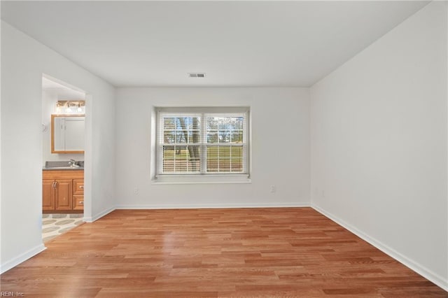 spare room with light hardwood / wood-style flooring and sink