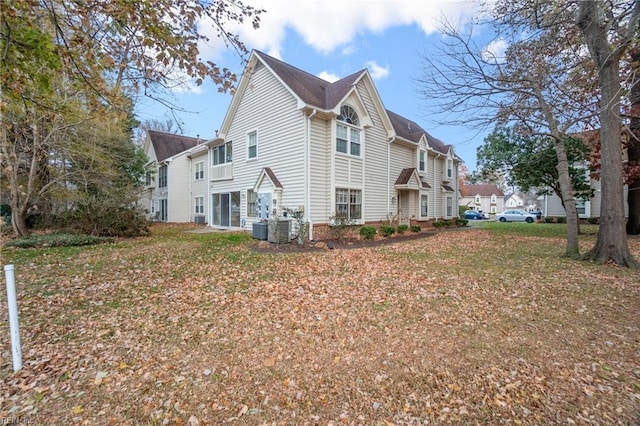 view of side of home with cooling unit and a lawn