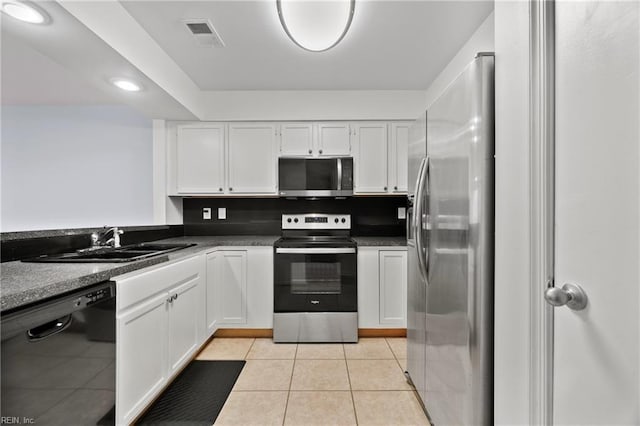 kitchen featuring light tile patterned floors, stainless steel appliances, white cabinetry, and sink